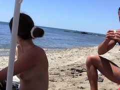 Topless girls playing in the water at a public beach