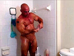 Soapy and oily shower with a muscular man