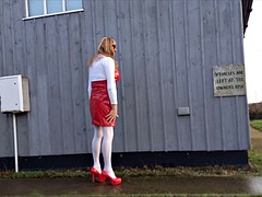 Shemale pees outdoors in a red PVC dress