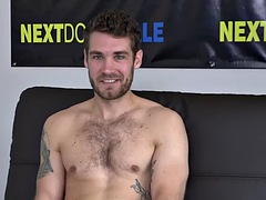 An athlete with a tattooed body at a casting solo jerks off during an interview