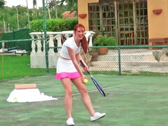 Redhead is playing tennis and besides unclothing to play with balls