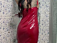 Latex fetish. Mistress Nika in a latex dress takes a shower. Watch as water drops cover Mistresss body