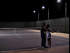 Young pretty brunette with dreadlocks takes some tennis lessons with a vigorous trainer