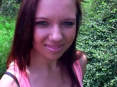 A redhead is shaking her ass and also her shaved pussy outside
