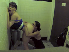 Two bitches are in the public bathroom, licking one another
